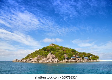 Pretty Small Island With Some Bungalows In Tropical Sea