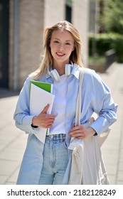 Pretty smiling girl university student holding notebooks looking at camera posing for outdoor portrait. College study programs, academic education ads, admission and scholarship. Vertical - Shutterstock ID 2182128249