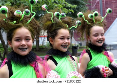 Pretty Smiling Identical Triplets Disguised To Participate In The 2015 Just For Laugh's Twins Parade, Montreal’s Place-des-Arts Sector, Montreal, Quebec, July 18, 2015