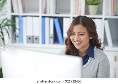 Pretty Smiling Indonesian Business Woman Looking At Computer Screen