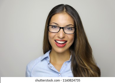 Pretty smiling woman in eyeglasses looking at the camera over gray background. Close up happy young woman multi race wearing eyeglasses showing toothy smile at the camera.
