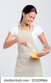 Pretty Smiling Woman Home Chef Beating Eggs With Whisk And Glass Bowl For Baking Or Food Preparation