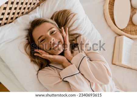 pretty smiling woman relaxing at home on bed in morning in pajamas top view from above happy having fun