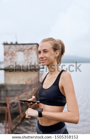 Pretty sports woman with gadgets outdoor