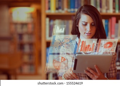 Pretty student working on her futuristic tablet pc in a library - Powered by Shutterstock