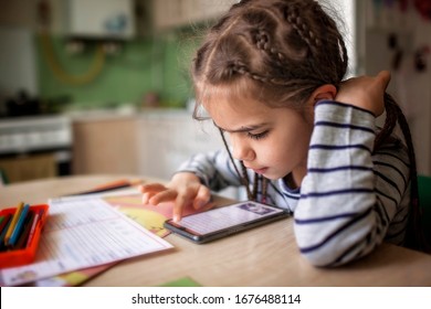 Pretty stylish schoolgirl studying math during her online lesson at home, social distance during quarantine, self-isolation, online education concept - Powered by Shutterstock