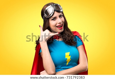 Pretty superhero girl making phone gesture on colorful background