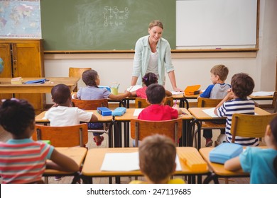 Pretty Teacher Talking To The Young Pupils In Classroom At The Elementary School