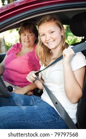 Pretty Teen Driver Fastening Her Seatbelt.  Mom Is About To Give Her A Driving Lesson.