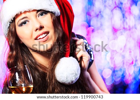 Pretty teenage girl in Christmas clothes on a party. Disco lights in the background.