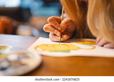 Pretty teenage girl draws a picture with poster paint. Front view of a drawing of a girl with a palette in her hand. A smiling young teenage girl draws a picture - Shutterstock ID 2241876825