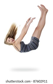 Pretty teenage girl upside down appears to be falling out of white space