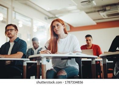 Pretty Teenage Student Paying Attention To Lecture In Classroom. Woman Studying At The College Classroom.