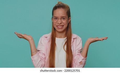 Pretty Teenager Girl Raising Hands In Indignant Expression, Asking Why, What Reason Of Failure, Demonstrating Disbelief Irritation By Troubles. Young Teen Child Kid Isolated On Blue Studio Background