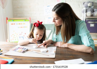 Pretty Three Year Old Girl Using Watercolor And Painting Plaster Figures With Her Mom During Homeschool