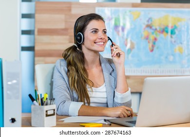 Pretty travel agent speaking to customer in the office