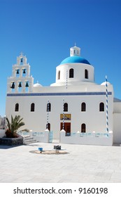 A pretty view of a church with a colorful blue dome in the Santorini cliff town of Oia.