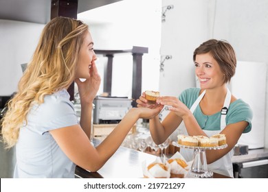 Pretty Waitress Serving Cupcake To Customer At The Coffee Shop