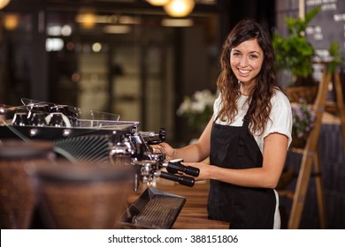 Pretty waitress using the coffee machine at the coffee shop - Powered by Shutterstock