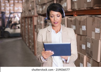 Pretty warehouse manager using tablet pc in a large warehouse