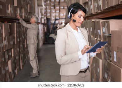 Pretty warehouse manager using tablet pc in a large warehouse - Powered by Shutterstock