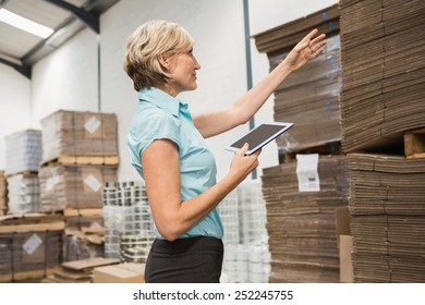 Pretty warehouse manager using tablet pc in a large warehouse - Powered by Shutterstock - Get 15% off with code: PIKWIZARD15