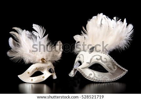 Pretty white venician golden carnival masks with feathers isolated on a mysterious black background