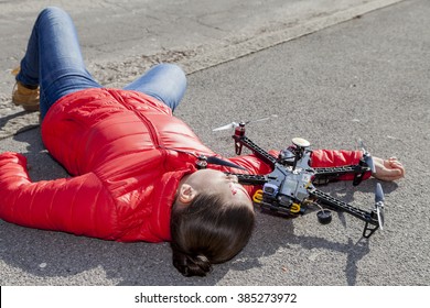 Pretty woman attacked by drone quadrocopter with bleeding head injuries,  lying on sidewalk in the city, space for text