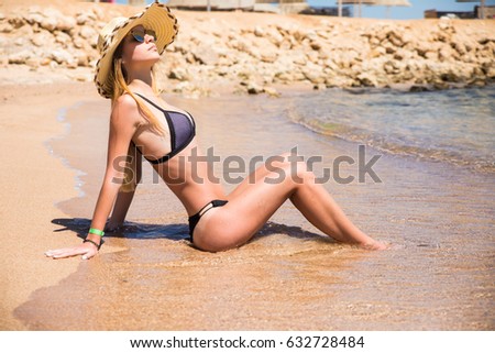 Pretty woman in bikini posing outdoor in summer on the beach vacation