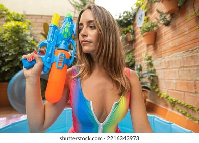 A Pretty Woman In Bikini With A Water Pistol In A Paddling Pool