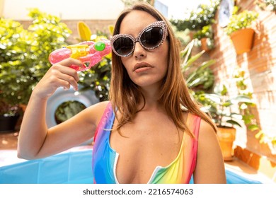 A Pretty Woman In Bikini With A Water Pistol In A Paddling Pool