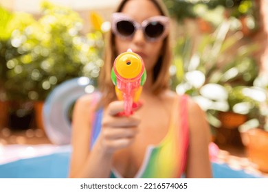 A Pretty Woman In Bikini With A Water Pistol In A Paddling Pool