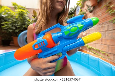 A Pretty Woman In Bikini With A Water Pistol In A Paddling Pool