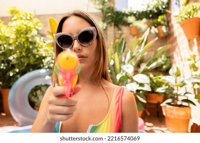 A Pretty Woman In Bikini With A Water Pistol In A Paddling Pool