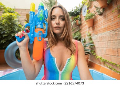 A Pretty Woman In Bikini With A Water Pistol In A Paddling Pool