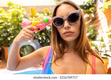 A Pretty Woman In Bikini With A Water Pistol In A Paddling Pool