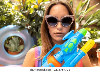 A Pretty Woman In Bikini With A Water Pistol In A Paddling Pool