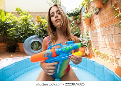 A Pretty Woman In Bikini With A Water Pistol In A Paddling Pool