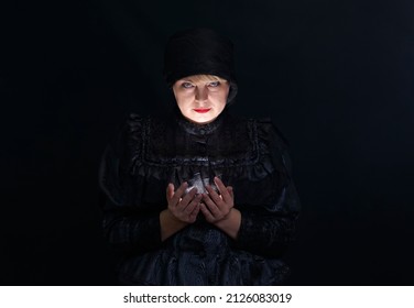 Pretty Woman In Black Clothes Holding A Light Source In Her Hands