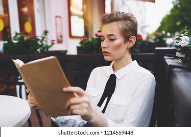 pretty woman with book in cafe                                - Shutterstock ID 1214559448