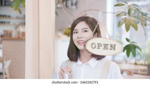 Pretty woman boss shopkeeper turning open sign in the morning - Powered by Shutterstock