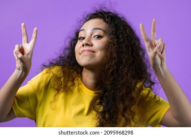 Pretty Woman With Curly Hair Showing With Hands And Two Fingers Air Quotes Gesture, Bend Fingers Isolated Over Violet Background. Not Funny, Irony And Sarcasm Concept. High Quality Photo