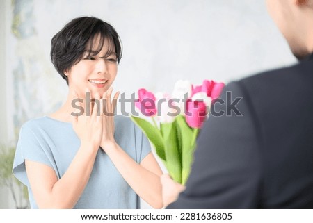 A pretty woman delighted by a bouquet of flowers.