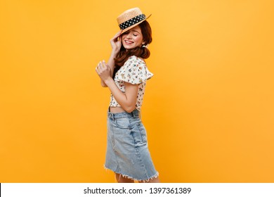 Pretty Woman In Denim Skirt And Cropped Light Top Puts On Boater And Smiles