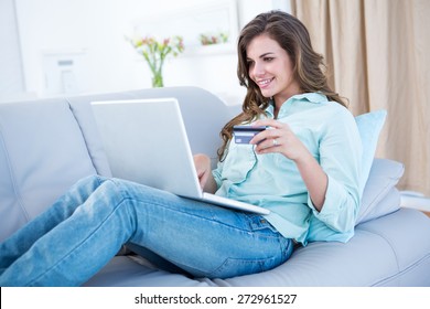 Pretty Woman Doing Online Shopping With Laptop At Home In The Living Room