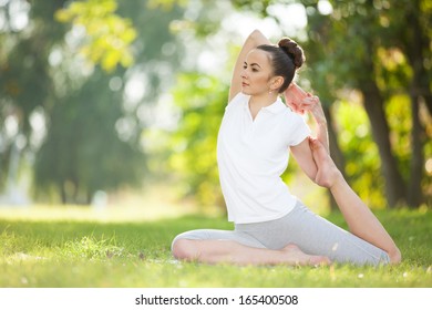 Pretty woman doing sport exercises in the park