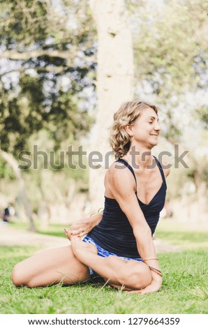 Pretty woman doing yoga exercises in the park
