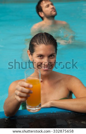Pretty woman drinking a juice at the pool