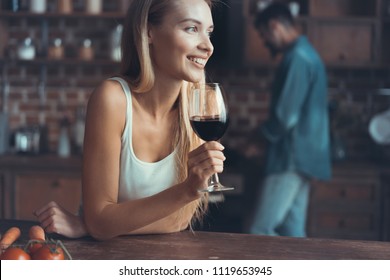 Pretty Woman Drinking Some Wine At Home In Kitchen .