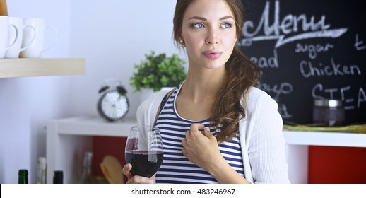 Pretty Woman Drinking Some Wine At Home In Kitchen